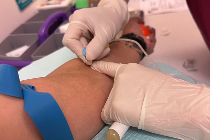 close up of nurse giving IV at harvest surrogacy